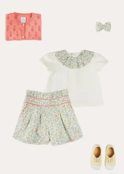 Pepa London Cordelia Floral Collar Top in Pink Made with Liberty Fabric (2-10yrs) | Cordelia Floral Shorts in Pink Made with Liberty Fabric (4-10yrs) | Floral Openwork Cotton Cardigan in Pink (2-10yrs) | Canvas Plimsolls in Cream (20-35EU) | Cordelia Floral Medium Bow Clip in Pink Made with Liberty Fabric