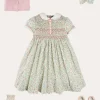 Pepa London Cordelia Floral Hand-Smocked Short Sleeve Dress in Pink Made with Liberty Fabric (12m-6yrs) | Openwork Cotton Cardigan in Pink (6mths-10yrs) | Leather Mary Jane Shoes in Pink (24-34EU) | Cordelia Floral Medium Bow Clip in Pink Made with Liberty Fabric | Celebration Short Socks with ruffle - Sand (0mths-10yrs)