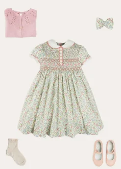 Pepa London Cordelia Floral Hand-Smocked Short Sleeve Dress in Pink Made with Liberty Fabric (12m-6yrs) | Openwork Cotton Cardigan in Pink (6mths-10yrs) | Leather Mary Jane Shoes in Pink (24-34EU) | Cordelia Floral Medium Bow Clip in Pink Made with Liberty Fabric | Celebration Short Socks with ruffle - Sand (0mths-10yrs)