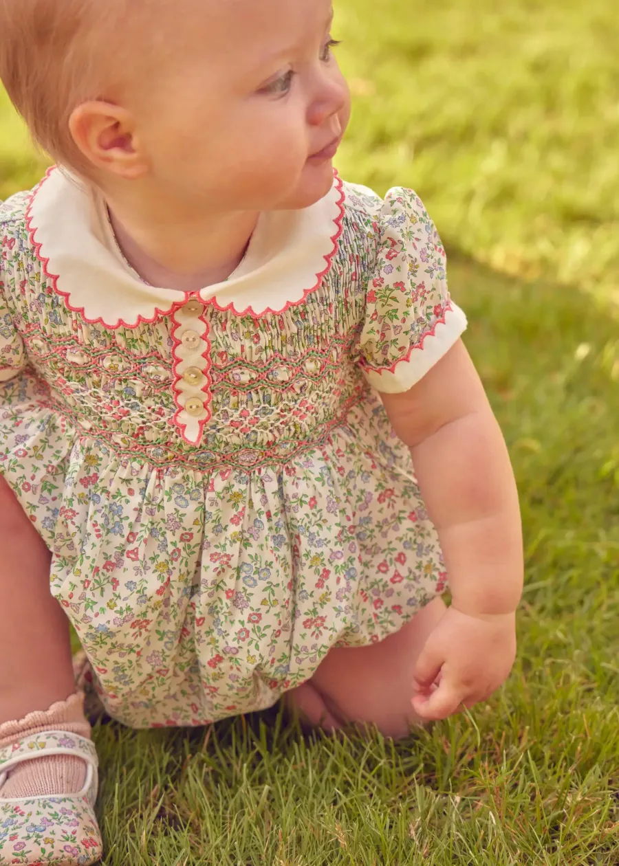Pepa London Cordelia Floral Hand-Smocked Short Sleeve Romper in Pink Made with Liberty Fabric (3m-2yrs) | Openwork Cotton Knitted Bonnet in Pink (S-L) | Openwork Cotton Cardigan in Pink (6mths-10yrs) | Cordelia Liberty Floral Mary Jane Pram Shoes in Pink (17-20EU) | Flower Fairies of the Spring Book in White | Cordelia Floral Small Bow Clip in Pink Made with Liberty Fabric | Openwork short socks White (0mths-8yrs)