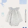 Pepa London Ellis Sleeveless Dress with Bloomer and Bows in Blue Made with Liberty Fabric (1-12m) | Openwork Detail Baby Cardigan in Blue (1-12mths) | Lace Detail Knitted Bonnet in Blue (1-6mths) | Lace Detail Knitted Booties in Blue | Ellis Dummy Clip in Blue Made with Liberty Fabric | BIBS Dummy in Blue