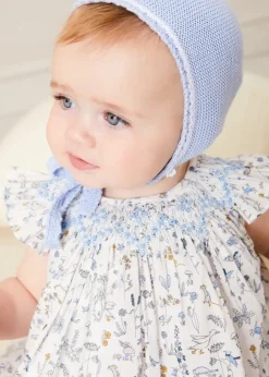 Pepa London Ellis Sleeveless Dress with Bloomer and Bows in Blue Made with Liberty Fabric (1-12m) | Openwork Detail Baby Cardigan in Blue (1-12mths) | Lace Detail Knitted Bonnet in Blue (1-6mths) | Lace Detail Knitted Booties in Blue | Ellis Dummy Clip in Blue Made with Liberty Fabric | BIBS Dummy in Blue