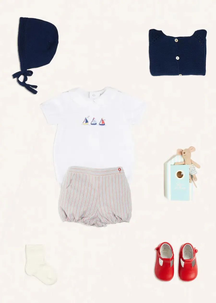 BOY Pepa London Embroidered Boat Motif Peter Pan Collar Bodysuit in White (1mth-3yrs) | Beaufort Striped Button Detail Bloomers in Red (3mths-3yrs) | Plain Cardigan in Navy (6mths-10yrs) | Openwork Knitted Bonnet in Navy (S-L) | T-Bar Pram Shoes in Red (17-20EU) | Ribbed Short Socks - Cream (0mths-10yrs)