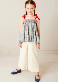 Pepa London Evelyn Floral Smock Detail Tie Strap Blouse in Red (4-10yrs) | Wide Leg Front Button Trousers in Beige (2-10yrs) | Mariner Collar Bold Stripe Jumper in White (2-10yrs) | Plain Linen Small Bow Hair Clip in Red