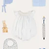 Pepa London Hand Smocked Sleeveless Romper in White (3-18mths) | Openwork Detail Baby Cardigan in Blue (1-12mths) | Lace Detail Knitted Bonnet in Blue (1-6mths) | Ellis Rounded Bib with Embroidery in Blue Made with Liberty Fabric | Lace Detail Knitted Booties in Blue | Ellis Dummy Clip in Blue Made with Liberty Fabric | My First Bunny in a Box - Blue | BIBS Dummy in Blue