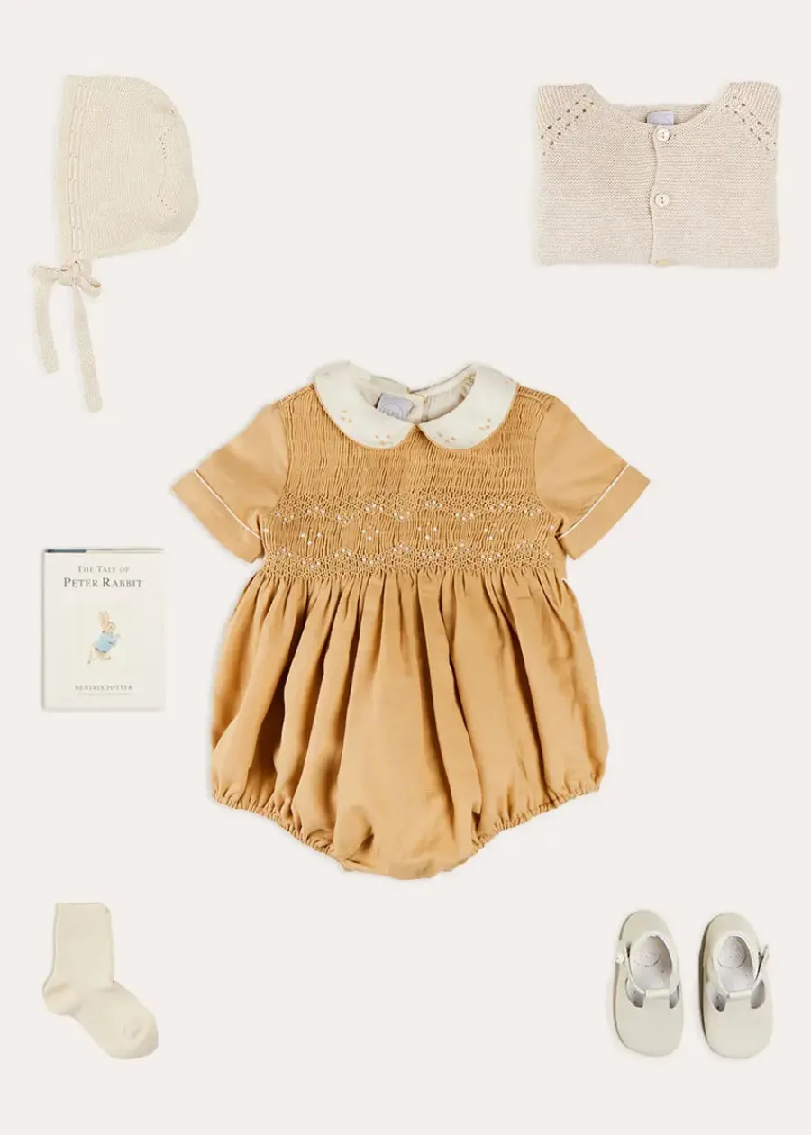 BOY Pepa London Peter Pan Collar Hand Smocked Short Sleeve Romper in Camel (6mths-2yrs) | Plain Cardigan in Cream (6mths-10yrs) | Openwork Knitted Bonnet in Beige(S-L) | T-Bar Leather Pram Shoes in Ivory (17-20EU) | Cotton Short Socks Cream (0mths-10yrs)