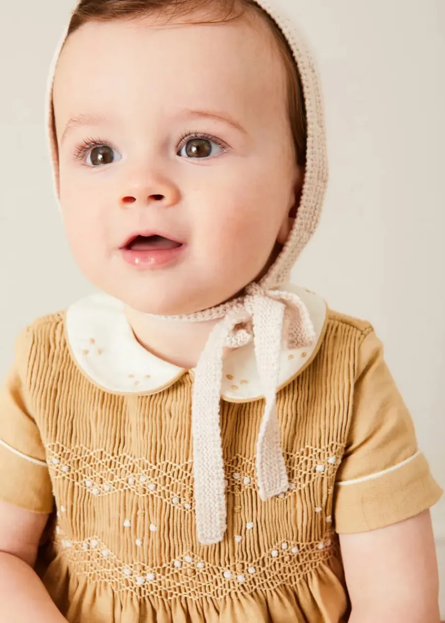 BOY Pepa London Peter Pan Collar Hand Smocked Short Sleeve Romper in Camel (6mths-2yrs) | Plain Cardigan in Cream (6mths-10yrs) | Openwork Knitted Bonnet in Beige(S-L) | T-Bar Leather Pram Shoes in Ivory (17-20EU) | Cotton Short Socks Cream (0mths-10yrs)